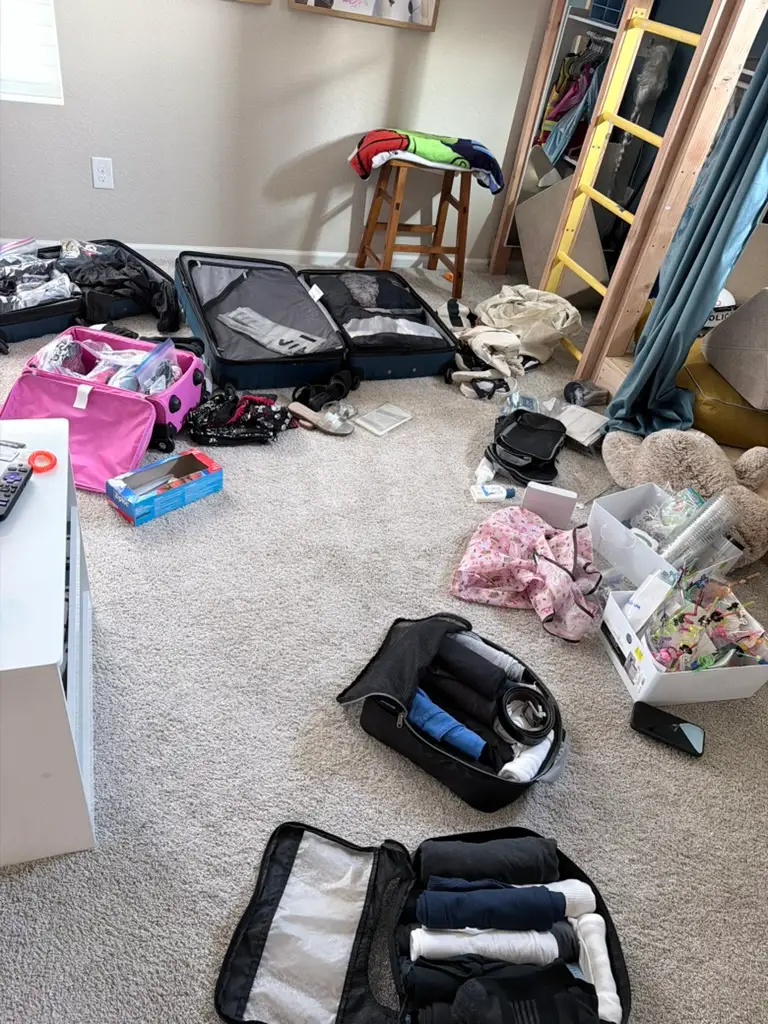 Messy room with packing mess everywhere. Suitcases, clothes, packing cubes