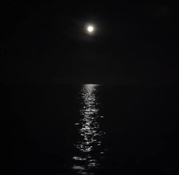 photo of the moon on Disney Cruise from the cabin reflecting light off the ocean