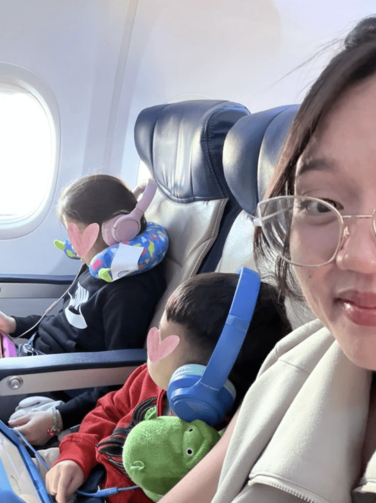 2 kids and a mom with wired headphones on in the airplane.