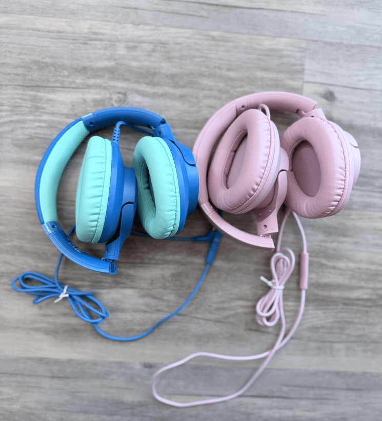 Pink and blue wired headphones that are folded up for travel. 