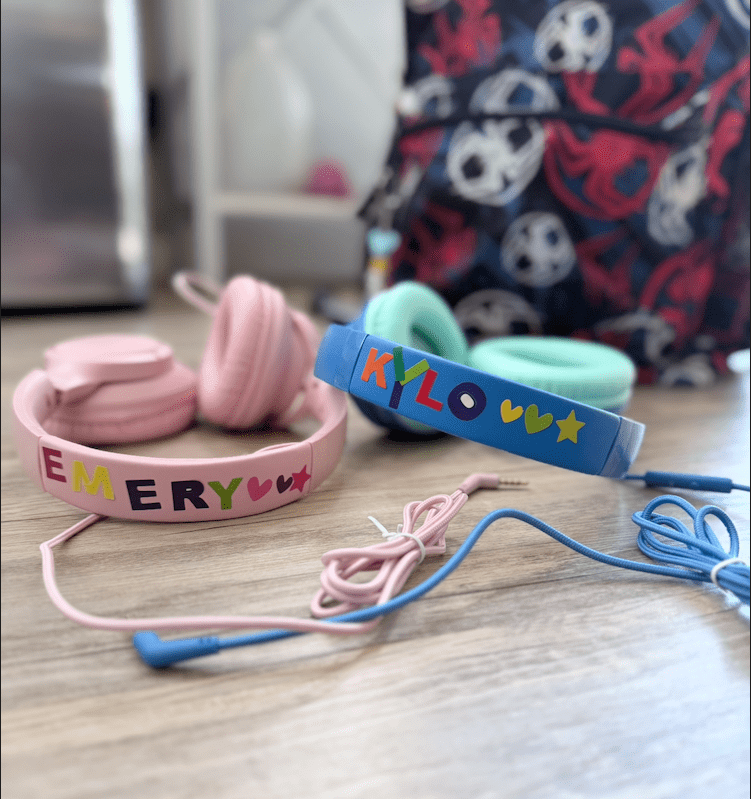 pink and blue wired headphones with names on them