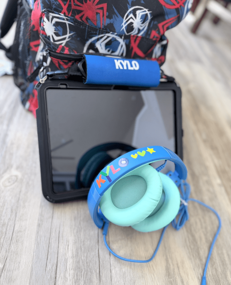 blue wired headphones and ipad ready for travel.